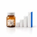 An amber medicine bottle of tablets beside paper bars rising in height, the tallest edged in blue