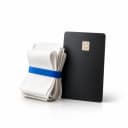A black payment card standing beside a folded stack of paper receipts held by a blue band