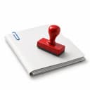 A red rubber stamp resting face down on a closed white folder with a blue paperclip